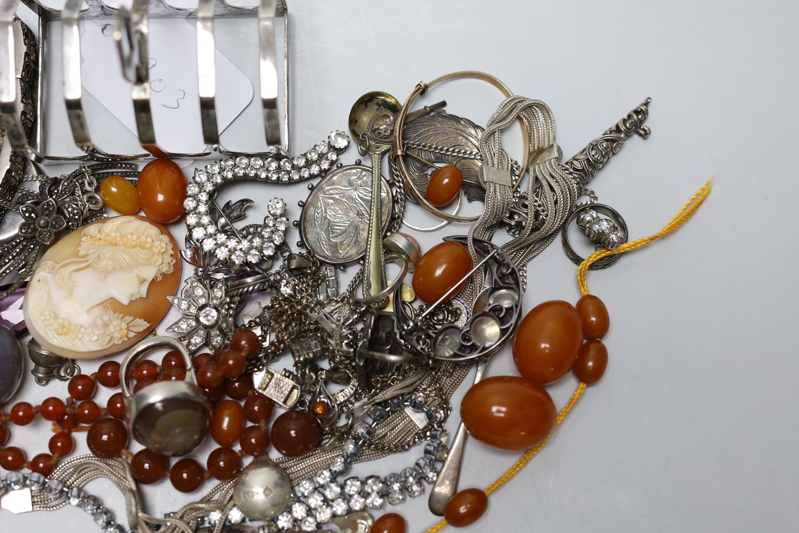 Mixed costume jewellery including a silver, marcasite and moonstone set flower brooch, faux amber beads, etc. and a silver five bar toast rack.